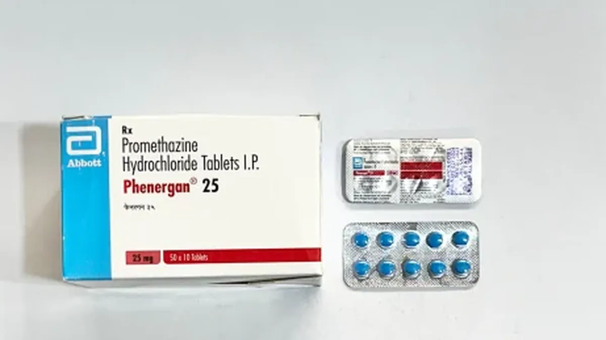 患者手持艾曲波帕25mg药盒，同时记录头痛恶心症状的日记